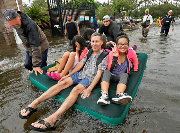 A family is evacuated on an air mattress from the Hurricane Harvey floodwaters in Houston, Texas August 29, 2017.