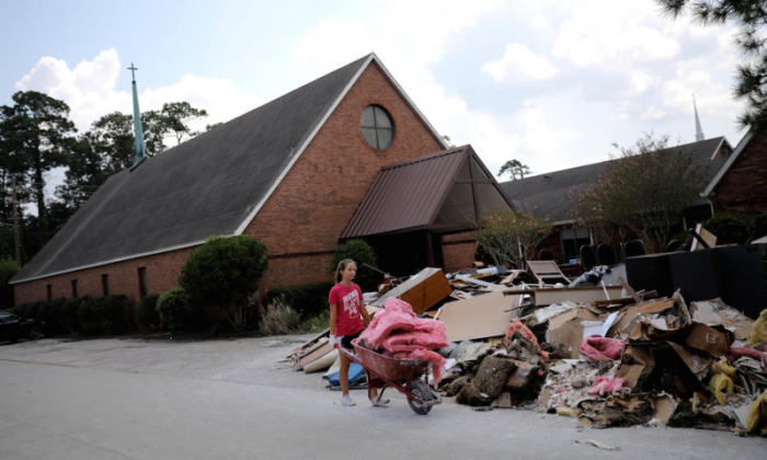A volunteer helps clean up the damage from a Lutheran church in the aftermath of Tropical Storm Harvey in Dickinson, Texas, U.S., September 2, 2017.