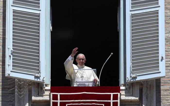 Pope Francis waves during his Angelus prayer on the Solemnity of the Assumption of the Blessed Virgin Mary in Saint Peter's Square at the Vatican, August 15, 2017.