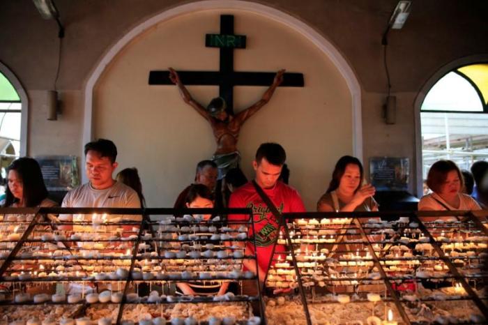 Filipino Catholic devotees light candles and offer prayers after attending a mass at a National Shrine of Our Mother of Perpetual Help in Baclaran, Paranaque city, metro Manila, Philippines on September 18, 2016.