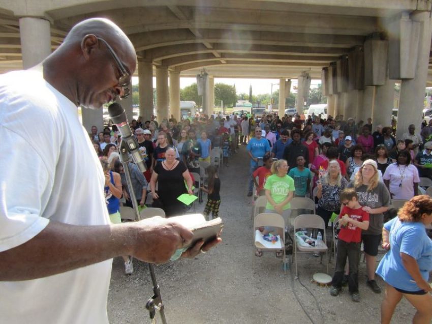 Charles Benson, associate pastor at Church Under the Bridge of Waco, Texas, reads from the Bible as part of their 25th anniversary worship celebration, held on Sunday, September 17, 2017.