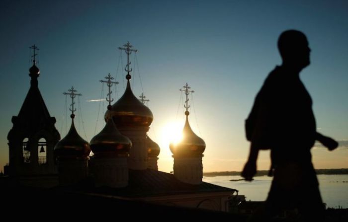 A man passes a church during a sunset in Nizhny Novgorod, Russia, July 11, 2017.