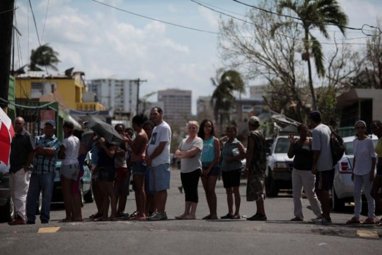 People stand in line for relief items to be distributed, after the area was hit by Hurricane Maria in San Juan, Puerto Rico, September 24, 2017.