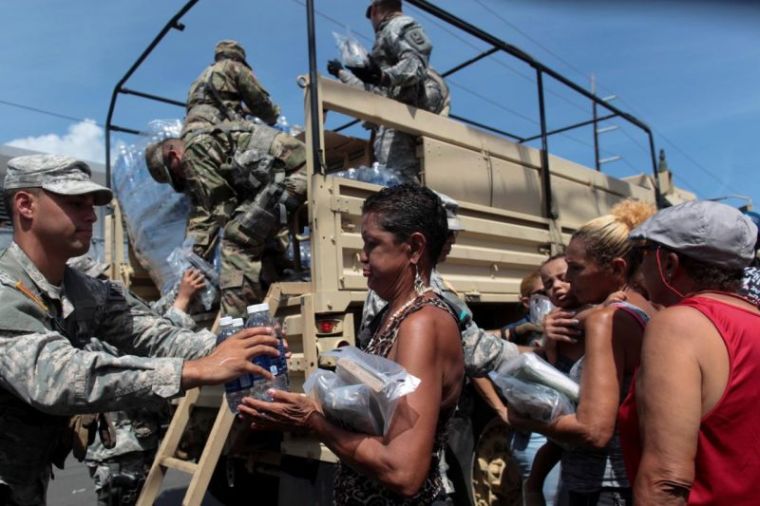 Soldiers of Puerto Rico's national guard distribute relief items to people, after the area was hit by Hurricane Maria in San Juan, Puerto Rico, September 24, 2017.