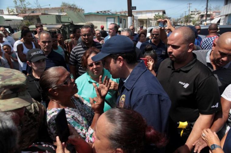 Puerto Rico's Governor Ricardo Rossello (C) talks to a woman during a distribution of relief items, after the area was hit by Hurricane Maria in San Juan, Puerto Rico, September 24, 2017.