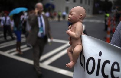 Credit : A pro-life activist holds a doll and banner while advocating his stance on abortion near the site of the Democratic National Convention in Charlotte, North Carolina on September 4, 2012.