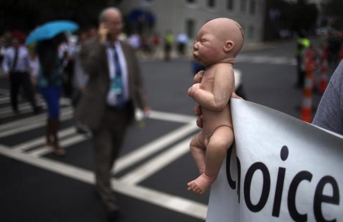 A pro-life activist holds a doll and banner while advocating his stance on abortion near the site of the Democratic National Convention in Charlotte, North Carolina on September 4, 2012.