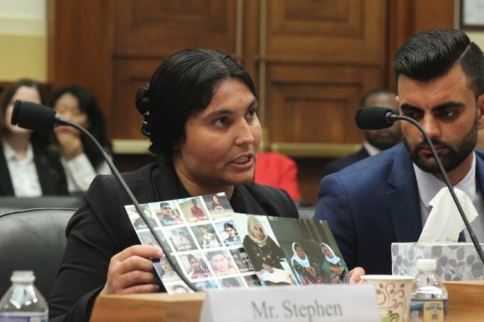 A Yazidi woman who was enslaved by the Islamic State for over nine months holds up pictures of family members as she testifies before a United States House of Representatives Foreign Affairs subcommittee hearing in Washington, D.C., on Oct. 3, 2017.