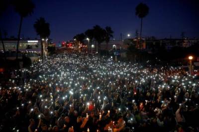 People hold candles and flashlights into the air during a memorial for Rachael Parker and Sandy Casey, Manhattan Beach city employees and victims of the October 1st Las Vegas Route 91 music festival mass shooting, in Manhattan Beach, California, U.S., October 4, 2017.