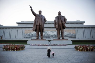 A woman and her daughter their respects at statues of North Korea founder Kim Il Sung (L) and late leader Kim Jong Il in Pyongyang October 11, 2015. Isolated North Korea marked the 70th anniversary of its ruling Workers' Party on Saturday with a massive military parade overseen by leader Kim Jong Un, who said his country was ready to fight any war waged by the United States.