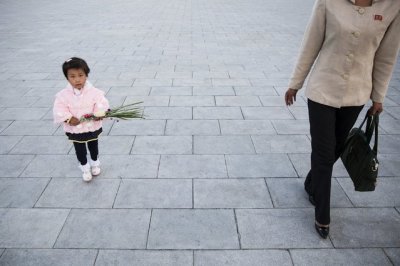 A woman and her daughter arrive to pay their respects at statues of North Korea founder Kim Il Sung and late leader Kim Jong Il in Pyongyang October 11, 2015. Isolated North Korea marked the 70th anniversary of its ruling Workers' Party on Saturday with a massive military parade overseen by leader Kim Jong Un, who said his country was ready to fight any war waged by the United States.