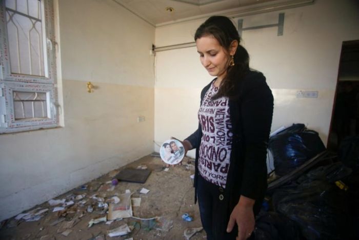 A Christian woman inspects a home in the town of Bartella east of Mosul, Iraq, after it was liberated from Islamic State militants November 23, 2016.