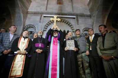 Iraqi Christians take part in a procession to erect a new cross over the Mar Korkeis church, after the original cross was destroyed by Islamic State militants, in the town of Bashiqa, Iraq, November 19, 2016.