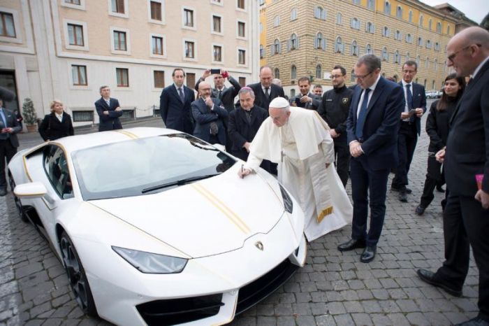 Pope Francis signs a Lamborghini Huracan prior to his Wednesday general audience in Saint Peter's square at the Vatican, November 15, 2017.