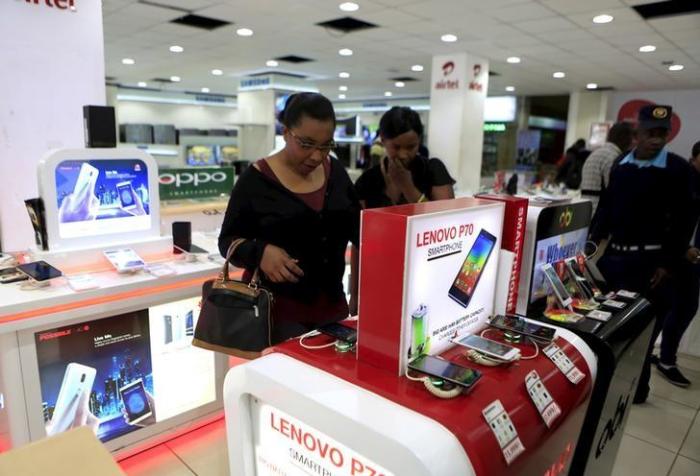Credit : People look at smartphones of Chinese brand Lenovo at a shop in Kenya's capital Nairobi September 2, 2015.