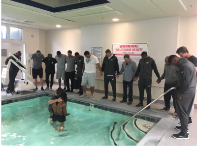 Philadelphia Eagles wide receiver Marcus Johnson is surrounded by teammates during his baptism in October 2017.