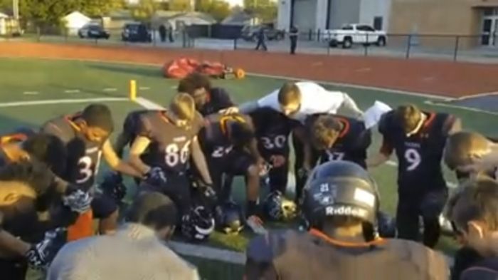 The Norman High School football team in Oklahoma prayers before the start of their game on Nov. 3, 2017.