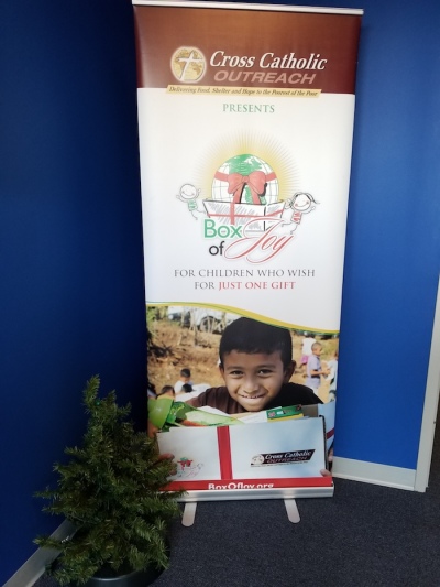 Box of Joy banner outside of warehouse where hundreds of volunteers gather to pack gifts for Children in need, Nov 18, 2017.
