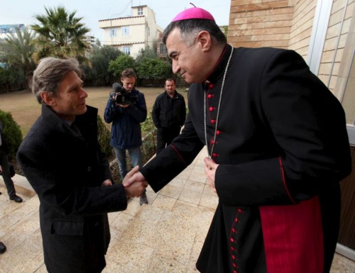 U.S. Assistant Secretary of State for Democracy, Human Rights and Labor Tom Malinowski, left, shakes hands with Archbishop Bashar Warda during his visit to the Chaldean Church in Erbil, Iraq.