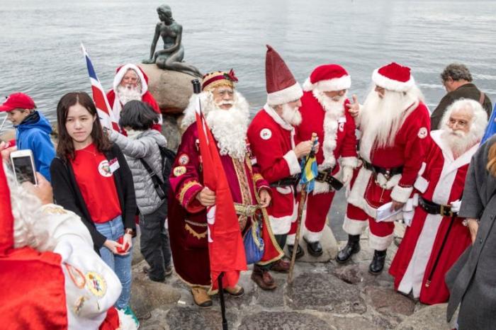 People dressed as Santa Claus take take part in the World Santa Claus Congress, an annual event held every summer at the amusement park Dyrehavsbakken, in Copenhagen.
