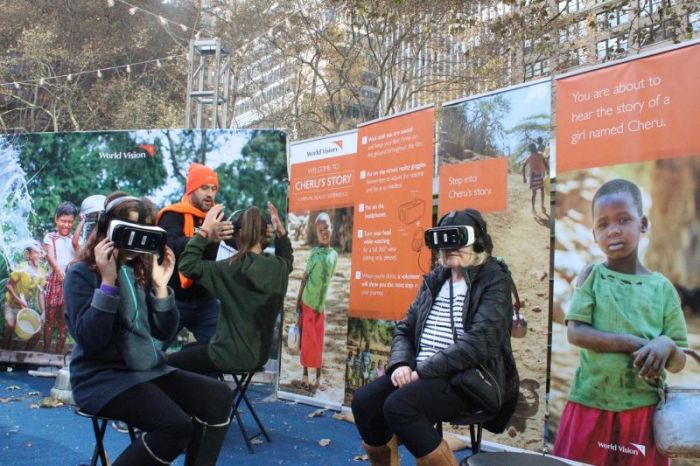 A volunteer helps participants virtually experience the life of a girl named Cheru in Kenya at World Vision's interactive pop-up shop in New York City's Bryant Park on Tuesday November 28, 2017.