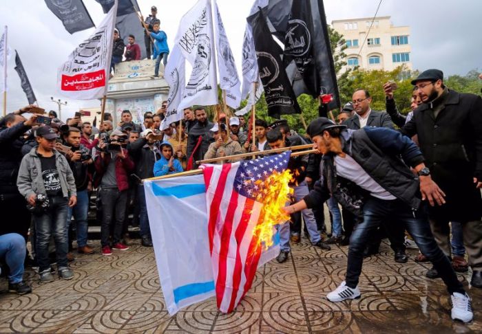 Palestinians burn an Israeli and a U.S. flag during a protest against the U.S. intention to move its embassy to Jerusalem and to recognize the city of Jerusalem as the capital of Israel, in Gaza City.