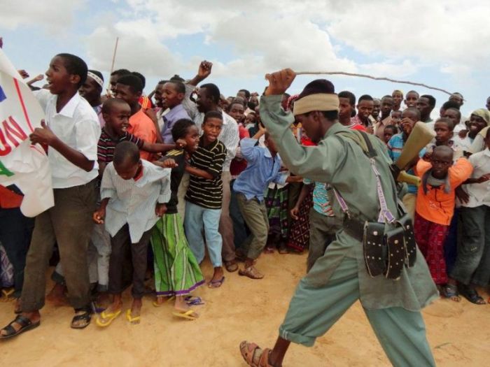 A file photo of an al Shabaab militant controlling residents participating in a demonstration in Somalia, October 27, 2011.