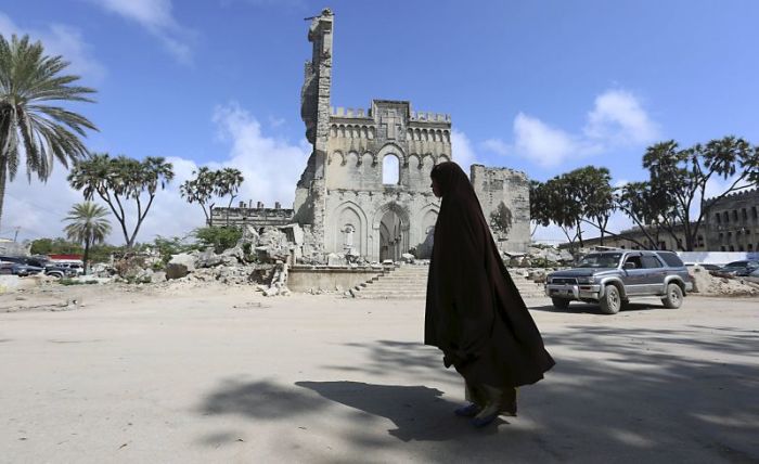 A woman walks past a section of Mogadishu Cathedral that was built by Italian authorities, in Mogadishu, Somalia, November 3, 2015.