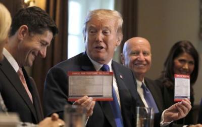 U.S. President Donald Trump holds sample tax forms as he promotes a newly unveiled Republican tax plan with House Republican leaders on November 02, 2017.