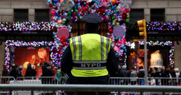 A member of the New York Police Department stands watch outside Saks Fifth Avenue on Christmas Eve in Manhattan, New York City, U.S.