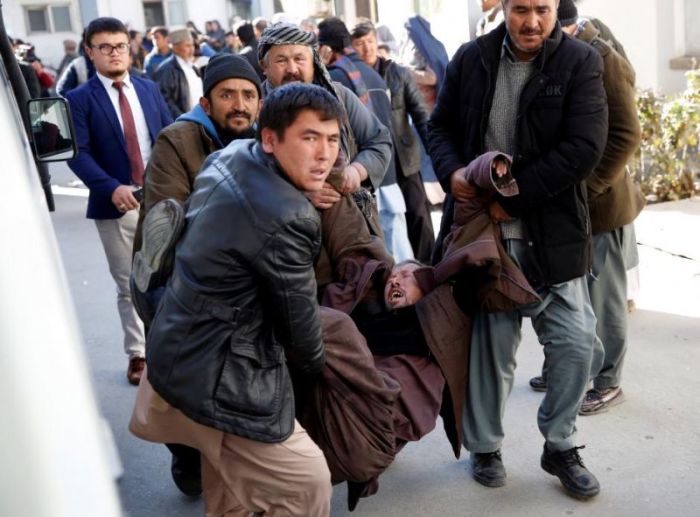 People carry a mourning man at a hospital after a suicide attack in Kabul, Afghanistan, December 28, 2017.