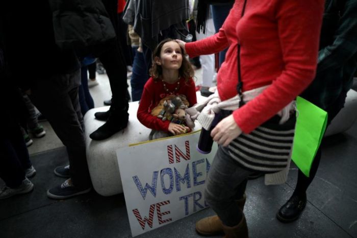 Credit : Ada Kennedy, 7, looks up at her mother as they participate in a protest march for survivors of sexual assault and their supporters in Hollywood, Los Angeles, November 13, 2017.