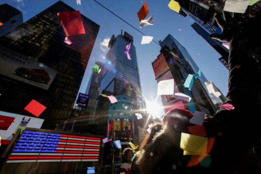 People look at confetti as it's thrown from the Hard Rock Cafe marquee as part of the annual confetti test ahead of the New Year's Eve ball-drop celebration in Times Square in New York City, December 29, 2017.