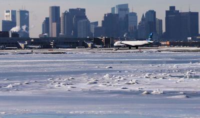Ahead of an incoming winter snow storm, a Jet Blue flight waits to take off from Logan International Airport next to the frozen waters of the Atlantic Ocean harbor between Winthrop and Boston, Massachusetts, U.S., January 3, 2018.