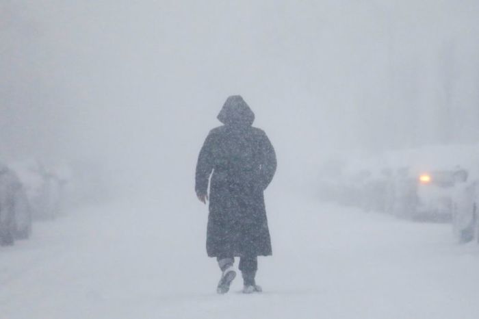Credit : A woman walks down the street during a blizzard in Long Beach, New York in this undated photo.