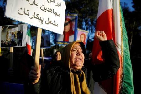 Opponents of Iranian President Hassan Rouhani hold a protest outside the Iranian embassy in Rome, Italy, January 2, 2018. The placard says: "Brave Iranian! Mujahideen is your friend! Fire will be your battle!"