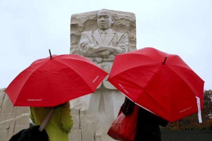 213682Sightseers hold their umbrellas against the rain as they tour the Martin Luther King Jr. Memorial in Washington November 19, 2015.