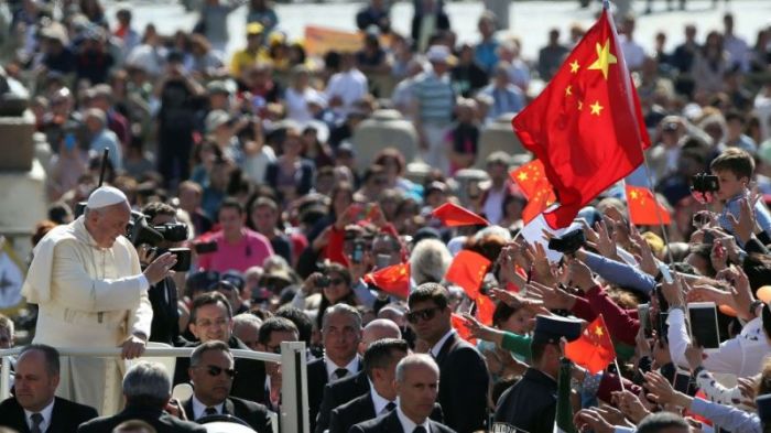 Pope Francis looking out at people waving Chinese flags in this undated photo.
