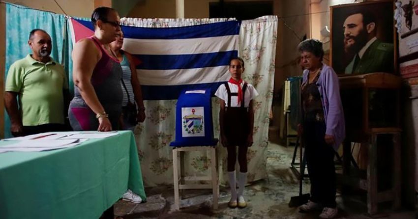 Election officials sing the national anthem beside an image of late Cuban President Fidel Castro moments before opening a polling station in Havana, Cuba, November 26, 2017.