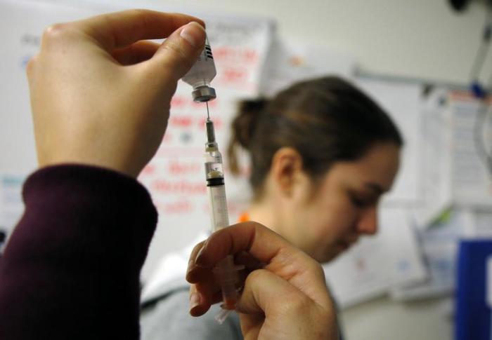 Nurses prepare a flu shot vaccine at a clinic in Boston.