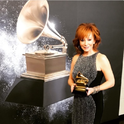 Country music singer and producer Reba McEntire holding her 2018 Grammy award for 'Best Roots Gospel Album.'