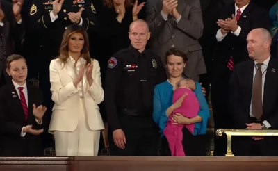 Albuquerque police officer Ryan Holets and his wife, Rebecca (R), stand next to First Lady Melania Trump.