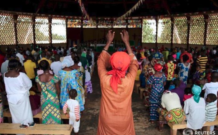 Members of an African congregation in the middle of praying during a Sunday mass back in 2015