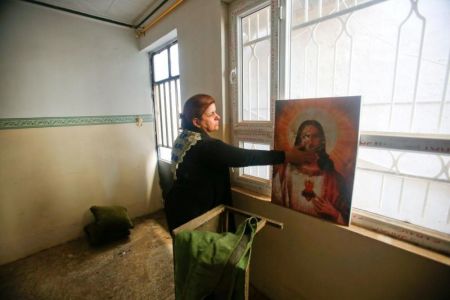 A Christian woman inspects a home in the town of Bartella east of Mosul, Iraq, after it was liberated from Islamic State militants November 23, 2016.