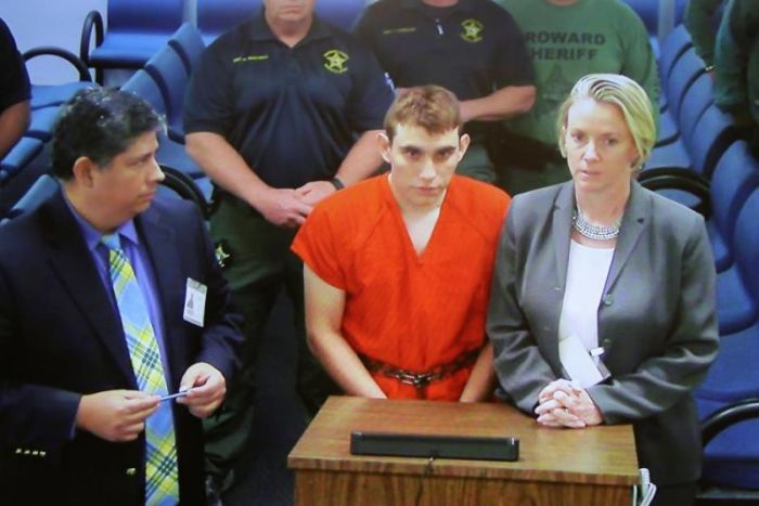 Nikolas Cruz (C) appears via video monitor with Melisa McNeill (R), his public defender, at a bond court hearing after being charged with 17 counts of premeditated murder, in Fort Lauderdale, Florida, on February 15, 2018.