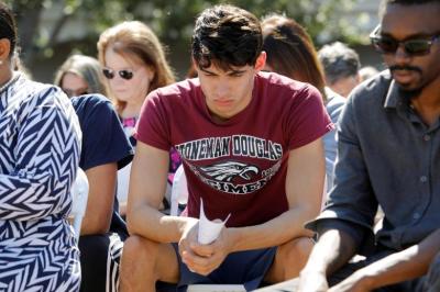 Daniel Journey (C), an 18-year-old senior at Marjory Stoneman Douglas High School in Parkland, attends a community prayer vigil for victims of yesterday's shooting at his school, at Parkridge Church in Pompano Beach, Florida, February 15, 2018. Journey said he lost two friends he had known and grown up with since they were 7 years old in the shooting.