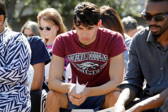 Daniel Journey (C), an 18-year-old senior at Marjory Stoneman Douglas High School in Parkland, attends a community prayer vigil for victims of yesterday's shooting at his school, at Parkridge Church in Pompano Beach, Florida, February 15, 2018. Journey said he lost two friends he had known and grown up with since they were 7-years-old in the shooting.