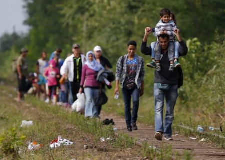 Syrian immigrants walk on a railway track after they crossed the Hungarian-Serbian border near Roszke, Hungary, August 25, 2015.
