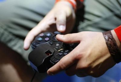 A visitor plays with a 'Playstation' at an exhibition stand at the Gamescom 2009 fair in Cologne August 22, 2009.