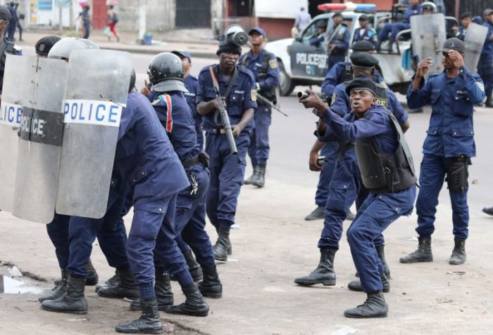 Policemen react after a protester threw a stone from Notre Dame Cathedral compound in Kinshasa, Democratic Republic of Congo, on February 25, 2018.